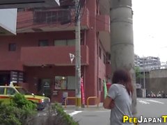 Asian leaves piss puddle in public street