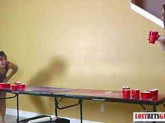 Zwei schöne Mädchen spielen Streifen Bier pong