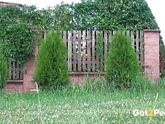 Dunkelhaarige Hottie pinkelt auf Gras in der Nähe des Flughafens